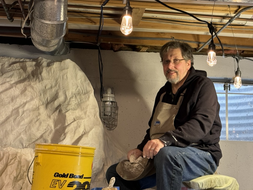 Kevin Wagner working on scenery at his model railroad layout.